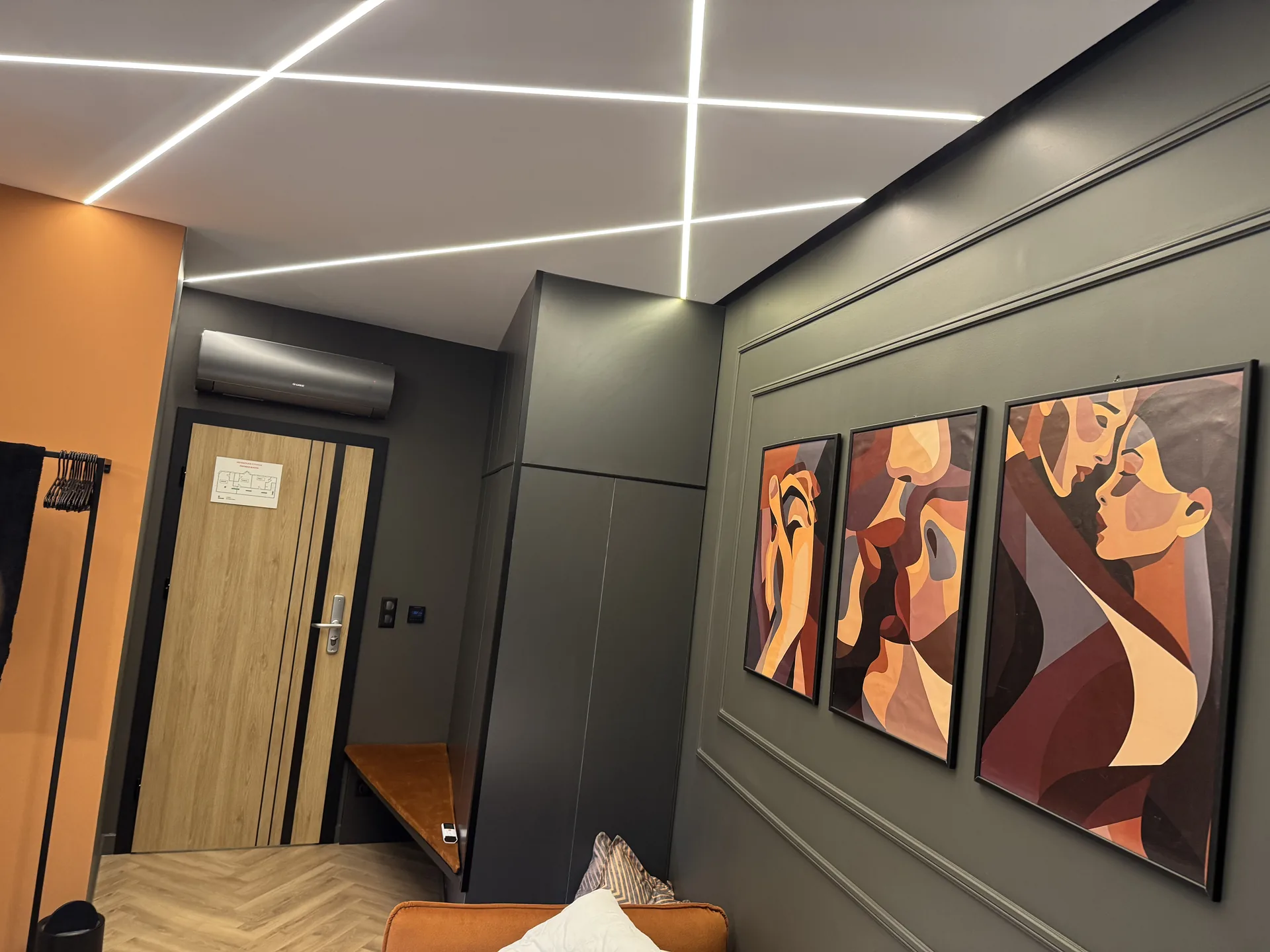 Sötét falburkolatú szobarész beltéri klímaegységgel – Premier Rooms, Szarvas